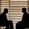 Two people discussing books and papers representing editorial consulting